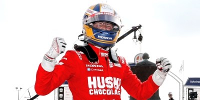 Marcus Ericsson de macacão vermelho e capacete azul e amarelo celebrando a vitória