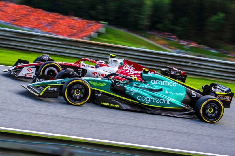 carro verde da Aston Martin de Sebastian Vettel, número 5, de lateral, com uma Alfa Romeo ao lado direito