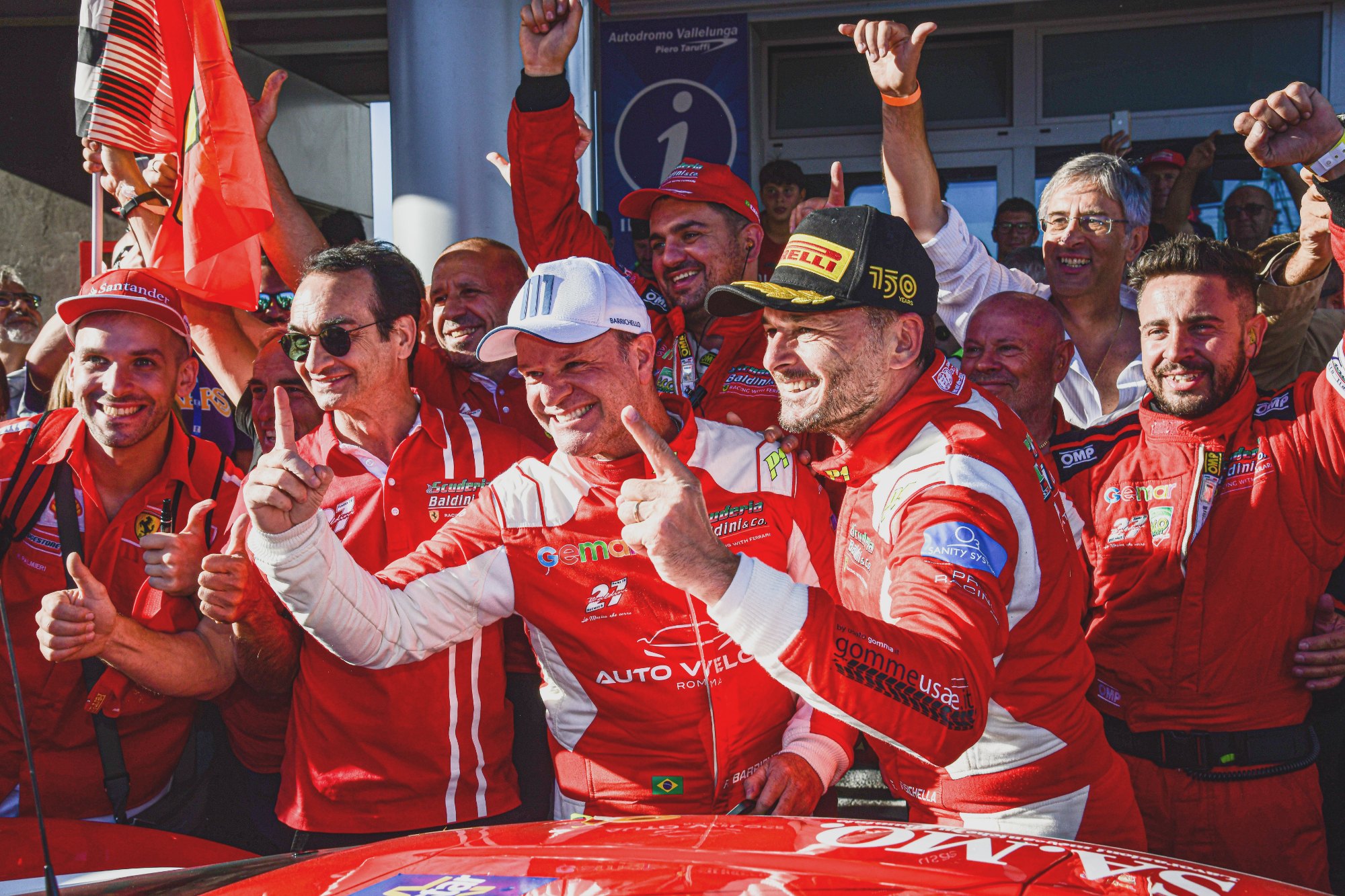 Rubens Barrichello e Giancarlo Fisichella, cercado por integrantes da escuderia Baldini, comemorando a vitória com o indicador levantado